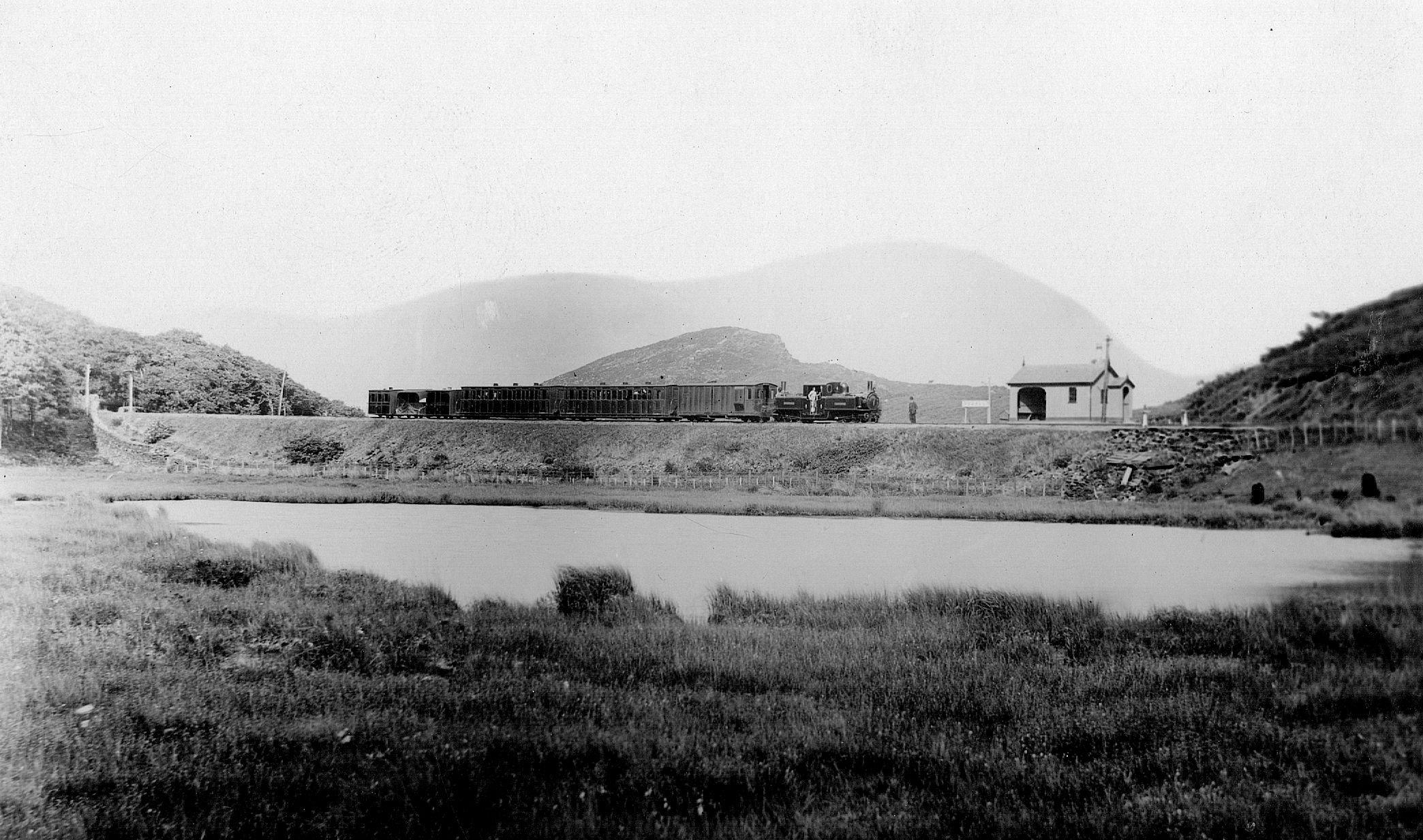 NGRS Collection 3 Ffestiniog Railway Double Fairlie loco with passenger train in distance passing lake.jpg